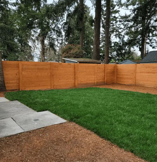 Backyard cedar privacy fence with fresh lawn and mulch border in Wilsonville OR – Oregon Quality Cuts